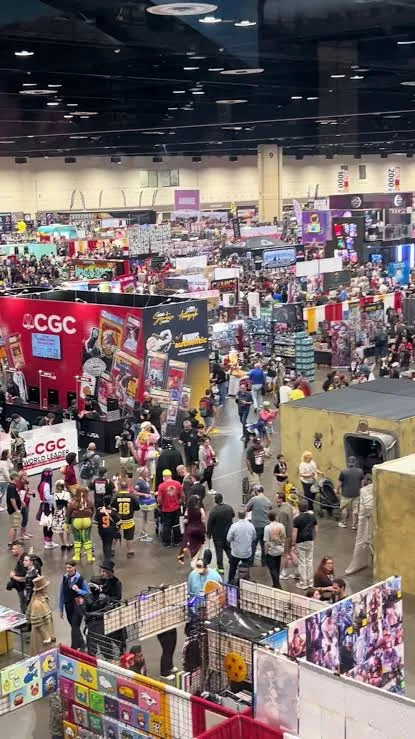 Convention-goers browsing trading card grading and collectibles booths on the show floor